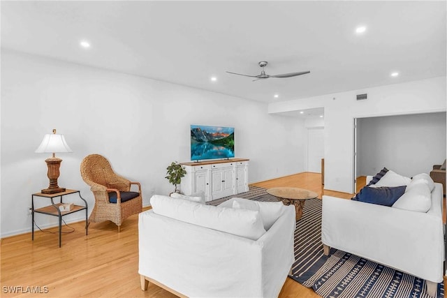 living room featuring ceiling fan and light hardwood / wood-style floors