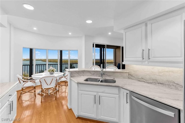 kitchen featuring sink, a water view, white cabinetry, light hardwood / wood-style flooring, and dishwasher