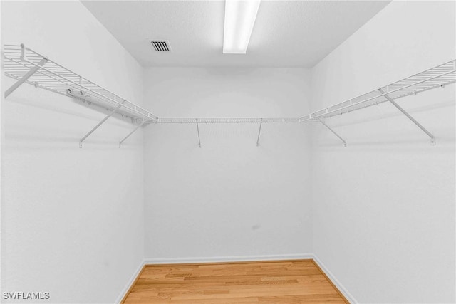 spacious closet with hardwood / wood-style floors