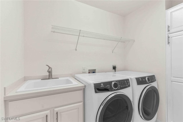 laundry room with independent washer and dryer, cabinets, and sink