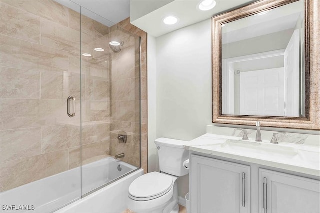 full bathroom featuring vanity, shower / bath combination with glass door, and toilet