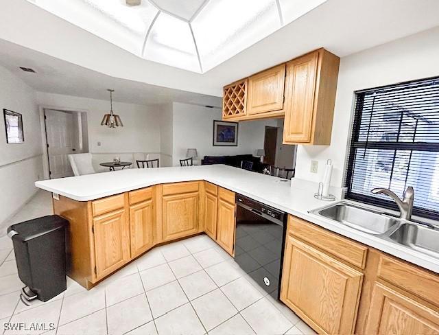 kitchen featuring light tile patterned flooring, pendant lighting, sink, black dishwasher, and kitchen peninsula