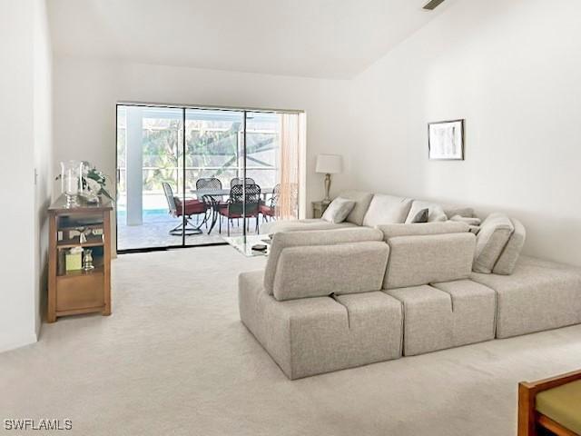 carpeted living room with vaulted ceiling