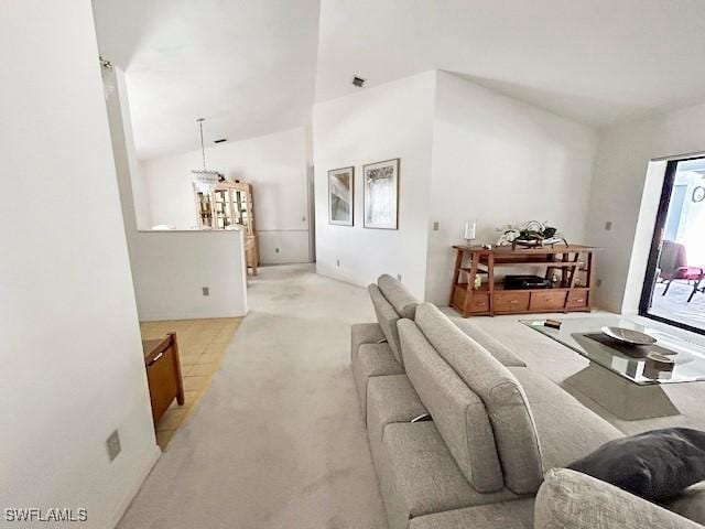 living room featuring lofted ceiling and light carpet