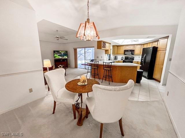 carpeted dining area with ceiling fan