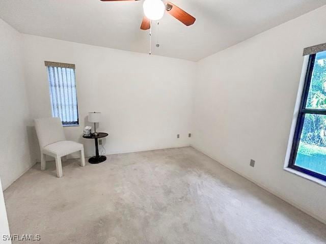 carpeted spare room featuring ceiling fan