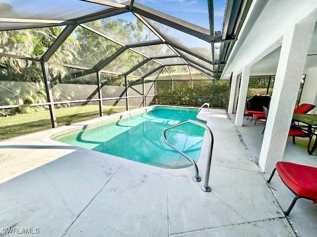 view of pool featuring a patio area and glass enclosure