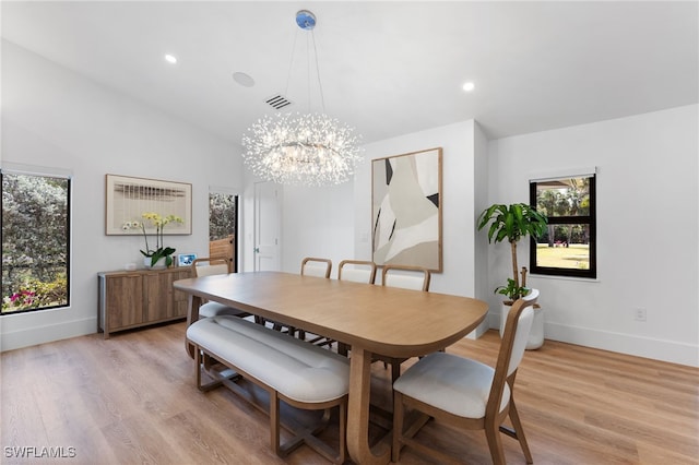 dining room featuring lofted ceiling, a notable chandelier, and light hardwood / wood-style floors