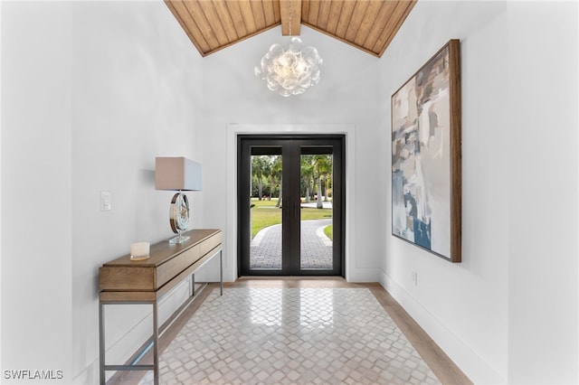 foyer entrance with french doors, vaulted ceiling with beams, a notable chandelier, wood ceiling, and light hardwood / wood-style flooring