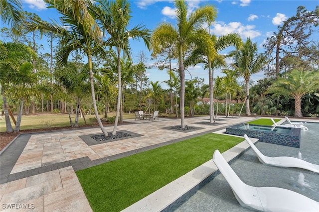 view of property's community with a yard and a patio