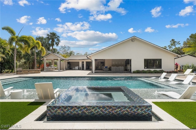 view of pool with an in ground hot tub, outdoor lounge area, and a patio area