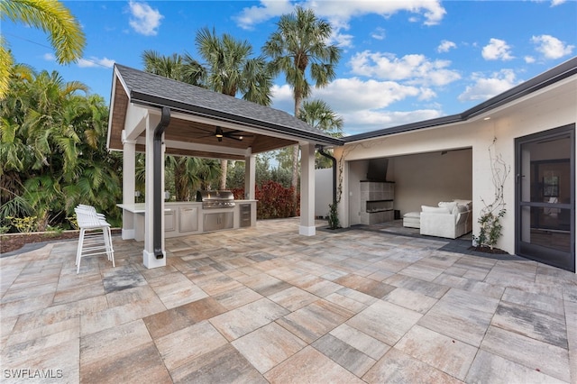 view of patio with exterior kitchen, a grill, and ceiling fan