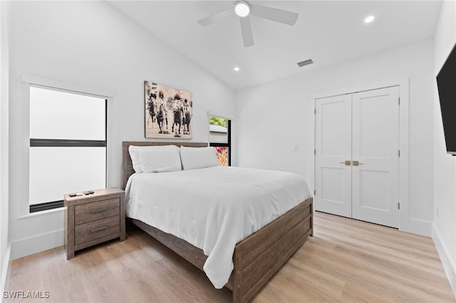 bedroom featuring vaulted ceiling, a closet, ceiling fan, and light wood-type flooring