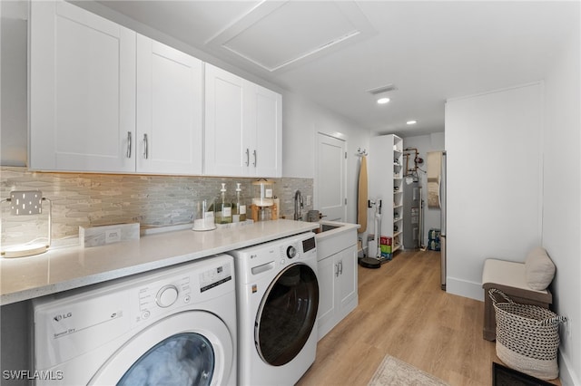 laundry area featuring sink, light hardwood / wood-style flooring, cabinets, and washer and dryer