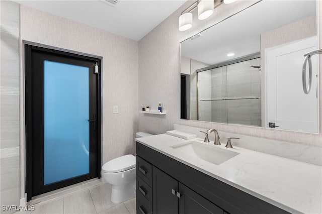 bathroom with tile patterned flooring, toilet, vanity, and walk in shower