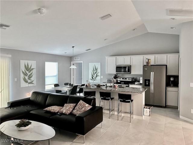 tiled living room featuring vaulted ceiling and sink