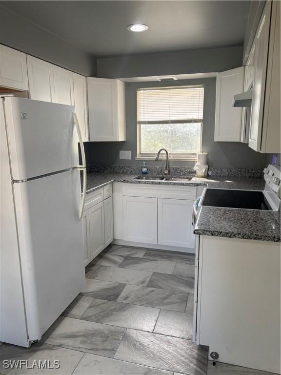 kitchen with white appliances, sink, and white cabinets