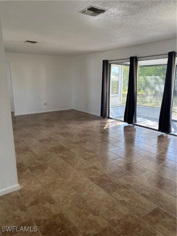 unfurnished room with a textured ceiling