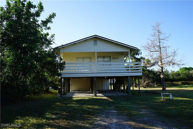 view of front of property with a deck and a front lawn