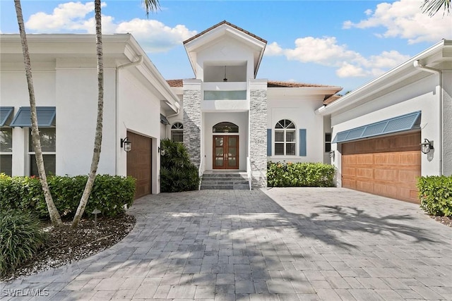 3747 Fountainhead Ln, Naples, FL 34103 - view of front of house with an attached garage, stucco siding, decorative driveway, and french doors