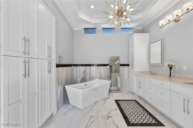 3747 Fountainhead Ln, Naples, FL 34103 - bathroom with crown molding, a raised ceiling, a chandelier, a freestanding tub, and marble finish floors