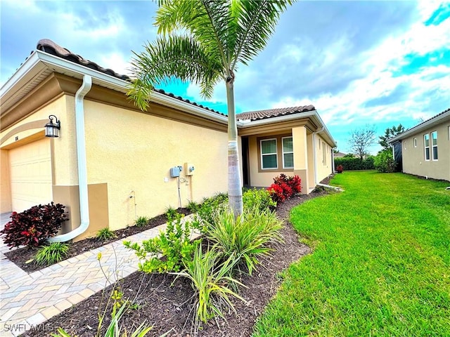 view of home's exterior with a garage and a lawn