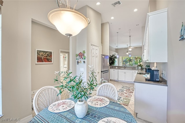 dining space featuring ceiling fan, sink, and light tile patterned floors