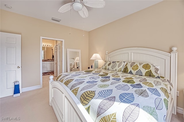 bedroom featuring ceiling fan, light colored carpet, and ensuite bathroom