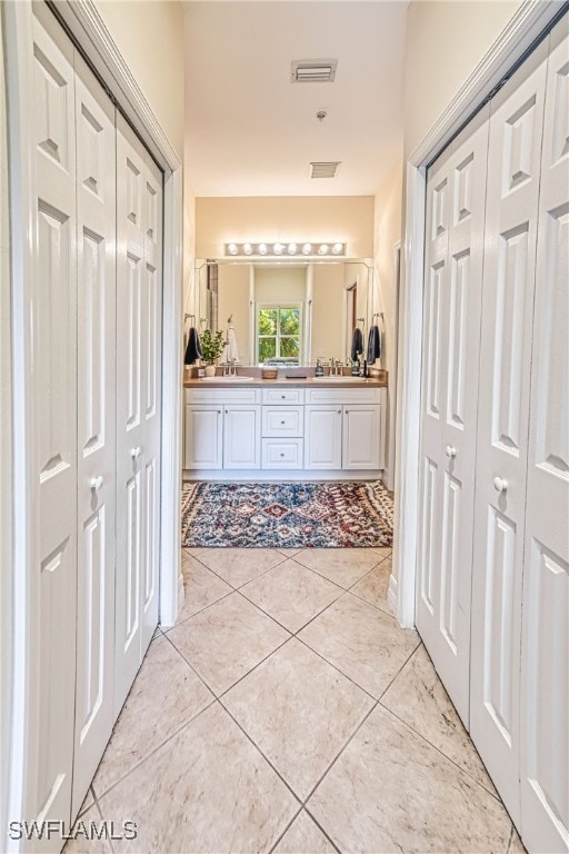 corridor with light tile patterned floors and sink