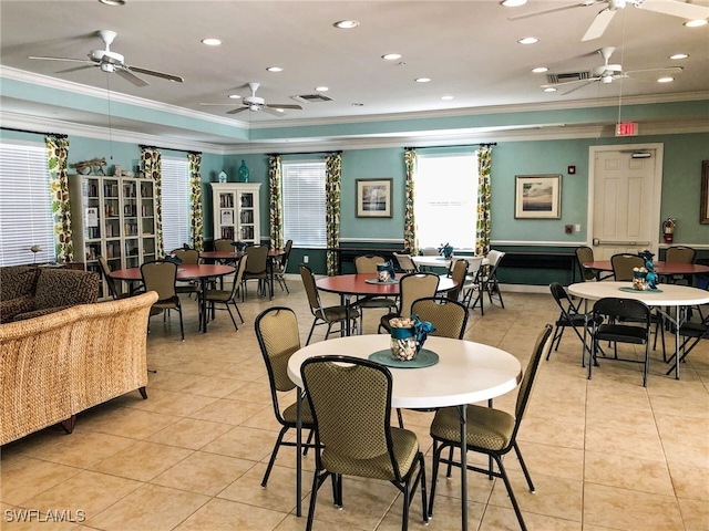 tiled dining room featuring ornamental molding and a tray ceiling