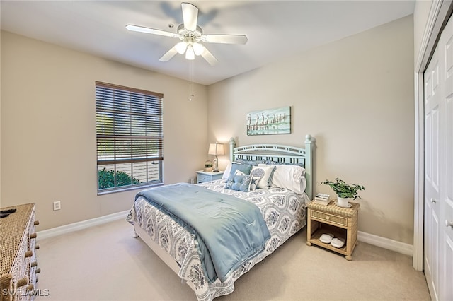 bedroom featuring ceiling fan, light colored carpet, and a closet