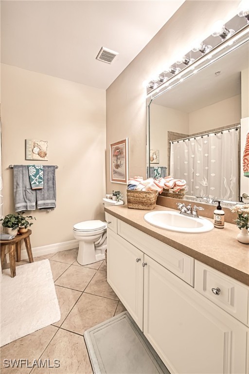 bathroom with vanity, toilet, and tile patterned flooring