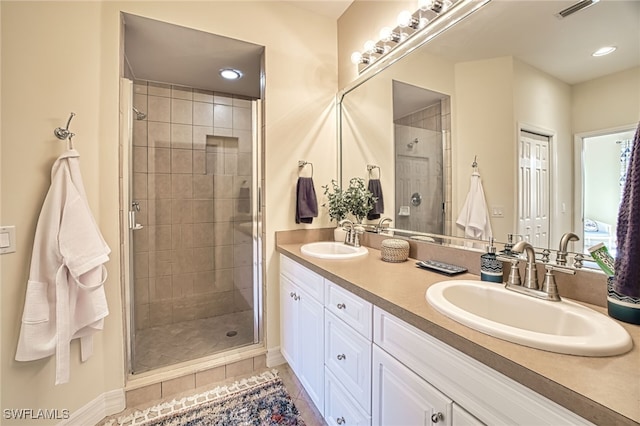 bathroom with an enclosed shower, vanity, and tile patterned floors