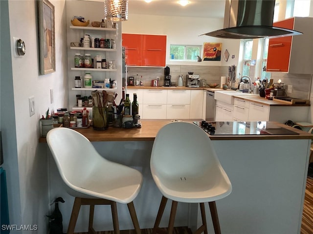 kitchen featuring tasteful backsplash, sink, island range hood, and white cabinets