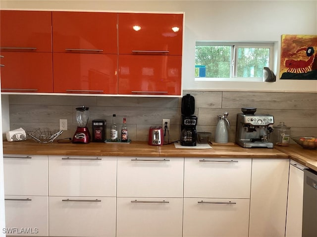 bar with tasteful backsplash, stainless steel dishwasher, and wood counters