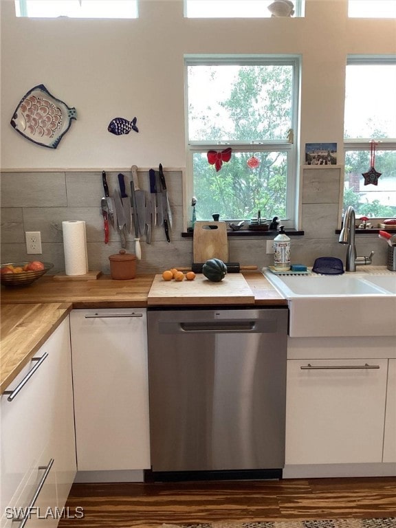 kitchen featuring white cabinetry, wood counters, dishwasher, and sink