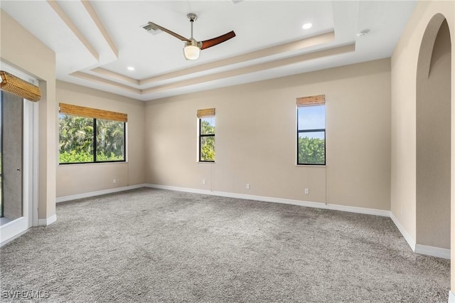 spare room featuring ceiling fan, a tray ceiling, and carpet flooring