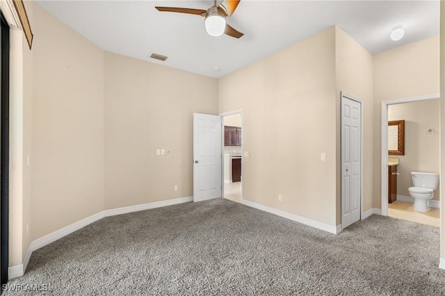 unfurnished bedroom featuring light carpet, ensuite bathroom, and ceiling fan