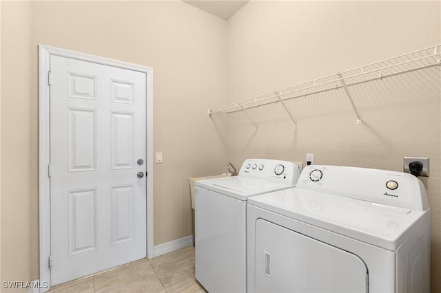 clothes washing area featuring light tile patterned flooring and washing machine and dryer