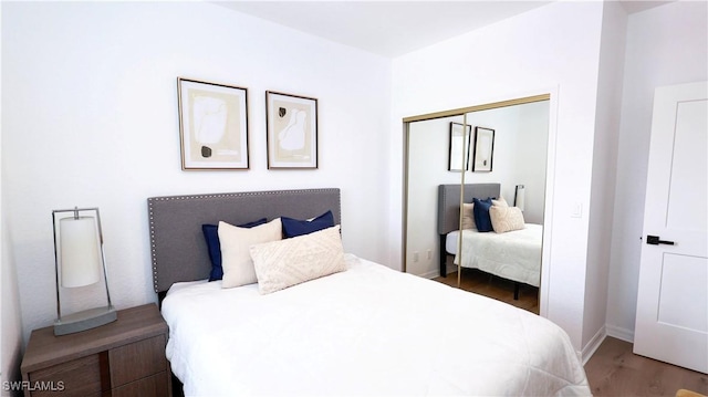 bedroom featuring a closet, wood finished floors, and baseboards