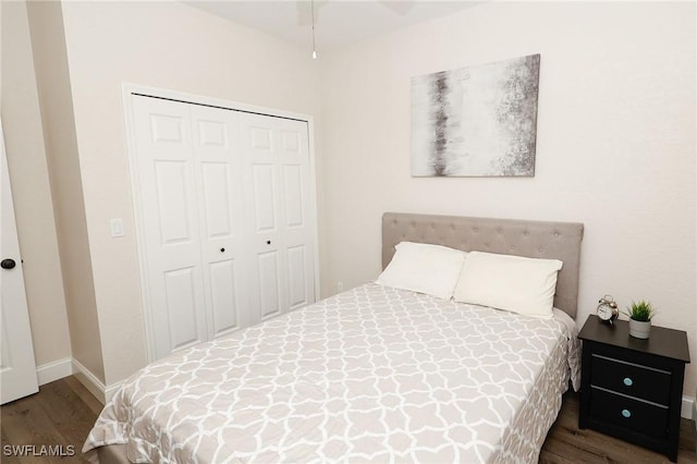 bedroom with wood finished floors, a closet, and baseboards