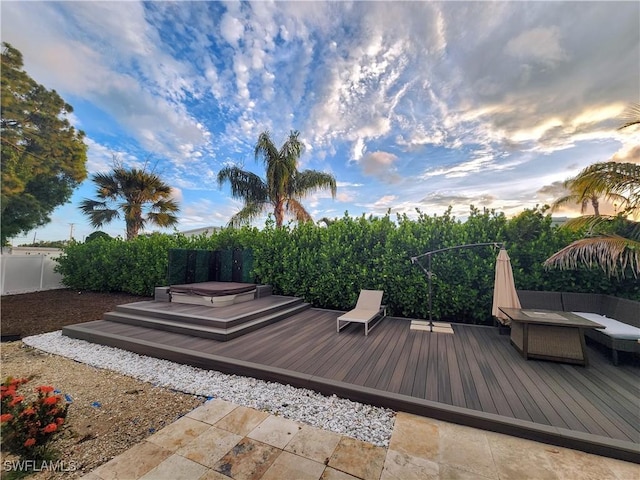 wooden terrace with a hot tub and fence