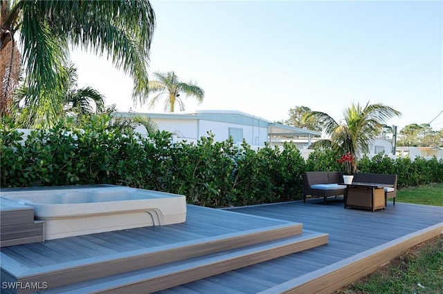 wooden deck featuring outdoor dining area and hot tub deck surround
