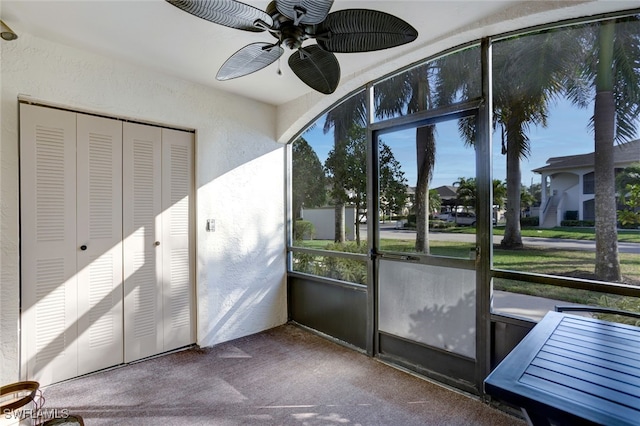 unfurnished sunroom featuring ceiling fan