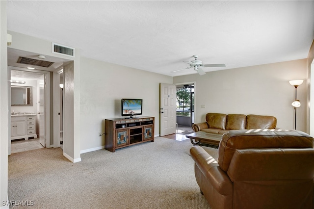 carpeted living room with ceiling fan