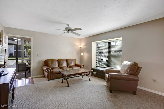 living room featuring a textured ceiling, plenty of natural light, light colored carpet, and ceiling fan