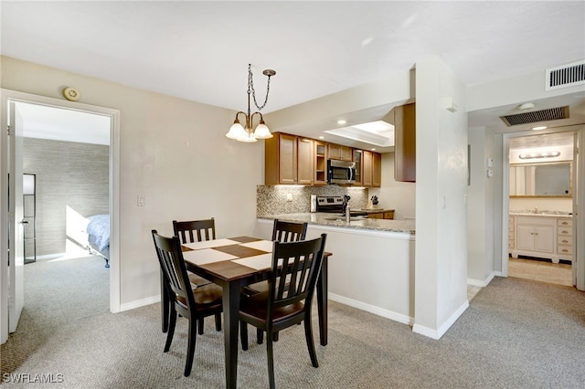 carpeted dining area featuring an inviting chandelier