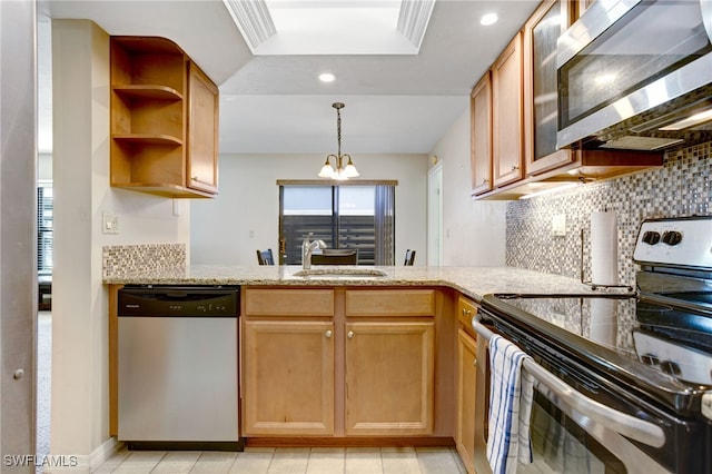 kitchen featuring sink, tasteful backsplash, light stone counters, a chandelier, and appliances with stainless steel finishes