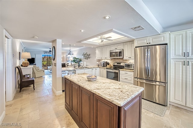 kitchen with ceiling fan, white cabinetry, stainless steel appliances, light stone counters, and kitchen peninsula