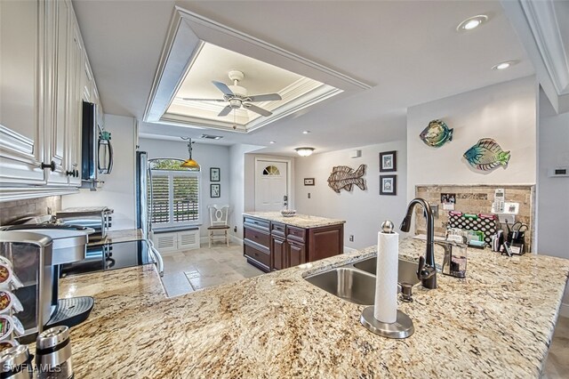 kitchen with sink, decorative backsplash, a tray ceiling, crown molding, and dark brown cabinets